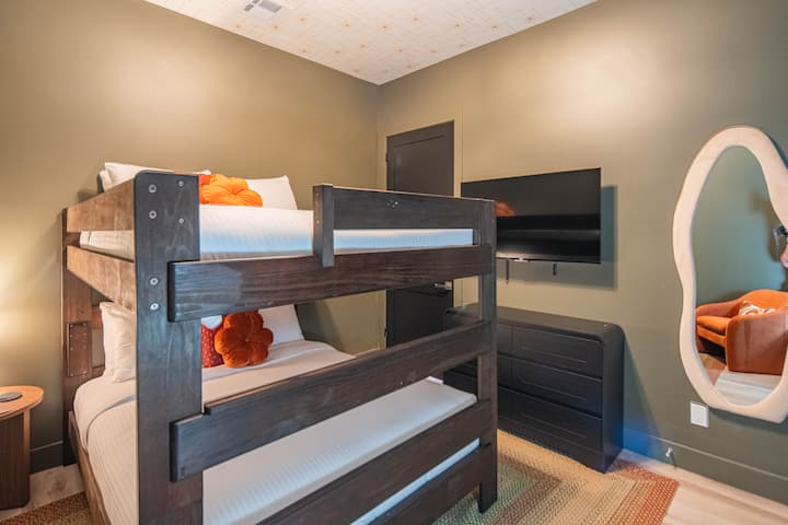 ️ Cozy bunk room with plush bedding, playful décor, and mounted Smart TV for easy entertainment. Warm tones and modern touches create a fun, comfortable retreat—perfect for kids, friends, or guests to relax and recharge.