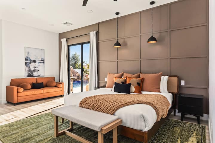 ️ Modern bedroom with plush bedding, warm décor, and sliding doors opening to pool views. Cozy sofa and stylish lighting create a relaxing retreat, perfect for restful nights, morning sunshine, and a comfortable stay.