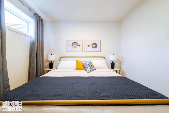 Camera da letto luminosa e accogliente con un soffice letto matrimoniale, cuscini morbidi e eleganti lampade laterali. Perfetto  per coppie e famiglie.