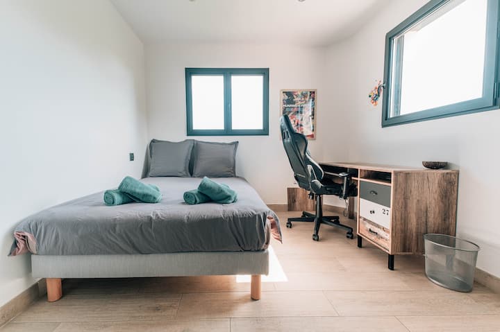 The room offers an ergonomic workspace with a desk and a suitable chair. Perfect for relaxing or working, with beautiful natural light. A quiet environment conducive to concentration.