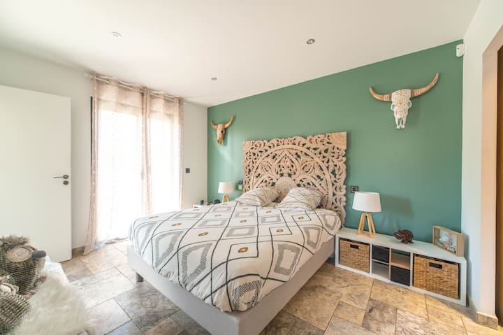 Enjoy a unique sculpted headboard that adds a handcrafted touch. The curtains let in soft natural light, perfect for resting after a day of exploring.