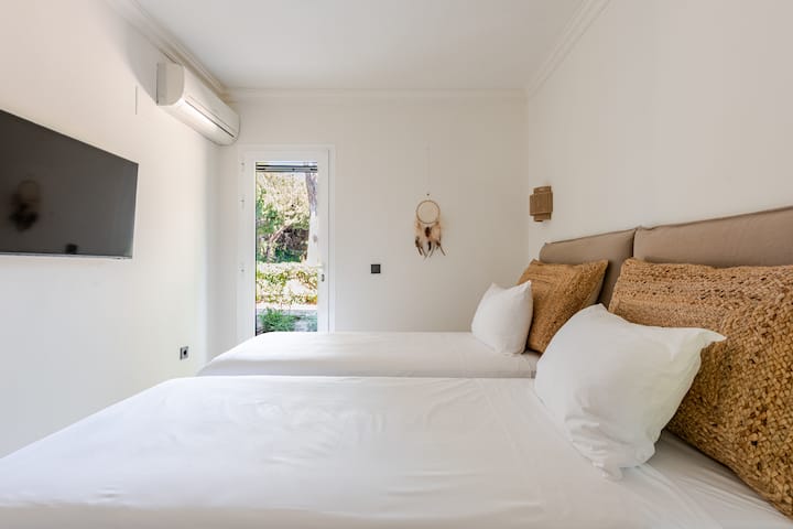 Dies ist das dritte Schlafzimmer. Die beiden 90 cm breiten Betten können entweder getrennt oder zusammengestellt werden. Du findest auch einen Fernseher und einen Kleiderschrank mit einer anständigen Größe und du hast Zugang zur Terrasse im Erdgeschoss.