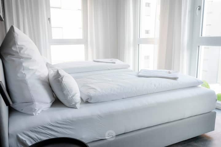 Два единечни кревета со димензии 90 x 200 см со ламби покрај креветот со интегриран USB и USB-C приклучок за полнење на мобилни телефони