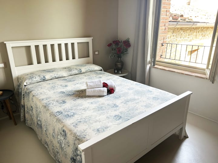 מיטה עם מגבות, פריטי נוי וחלון