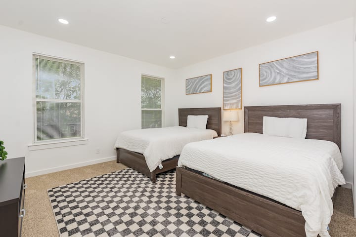 غرفة نوم مصممة بأناقة تحتوي على سريرين كبيرين وتلفزيون أنيق 55بوصة وخزانات واسعة مزدوجة وحمام داخلي خاص مصمم لاستضافة ما يصل إلى 4 ضيوف وتجديد طاقتك بشكل مريح.