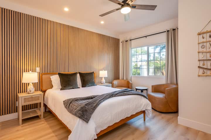 Esta suite tamaño queen cuenta con una acogedora cama tamaño queen, una elegante pared vertical de listones de madera, sillas decorativas de cuero e iluminación moderna. Con sus tonos suaves y detalles de diseño, ¡este espacio ofrece comodidad y estilo elevado!