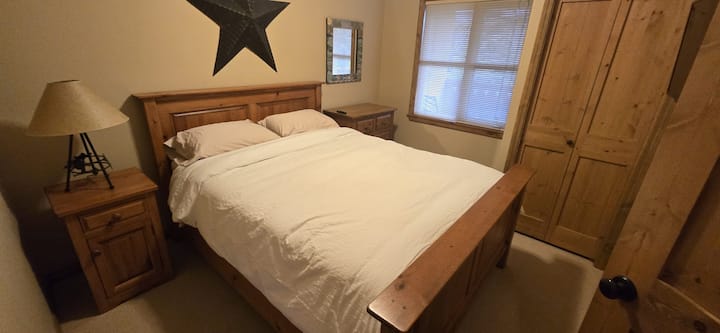 Dormitorio queen con TV inteligente y ventana con vista al patio. Baño compartido en la planta superior.