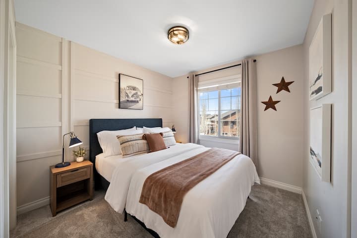 Cette élégante chambre à l'étage dispose d'un lit queen size confortable avec des draps propres et confortables, des stores, des rideaux occultants, des tables de chevet, beaucoup d'espace de rangement, un porte-bagages, des serviettes pour les invités et une vue sur la cour arrière et le parc.