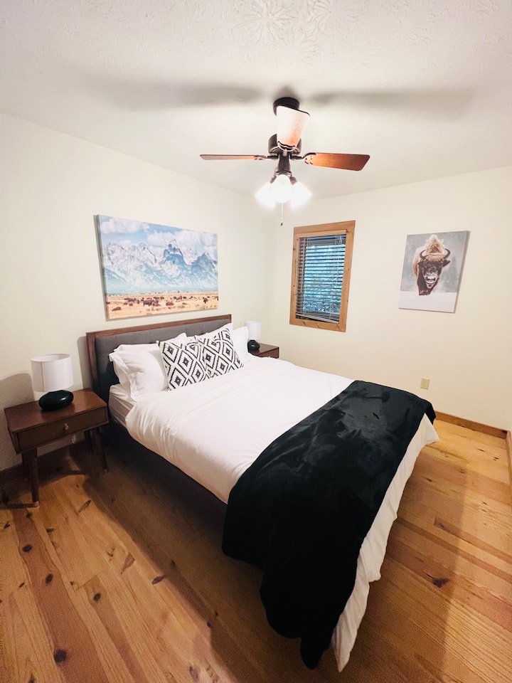 Cozy retreat with queen bed, rustic decor, and mountain-themed art for a relaxing stay in the mountains.