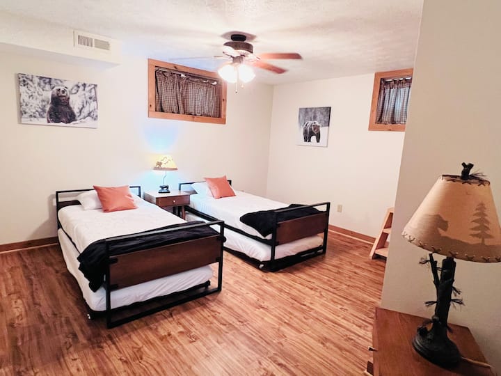 Kids’ room with two twin beds plus trundles, rustic wildlife decor, and plenty of space for fun sleepovers.