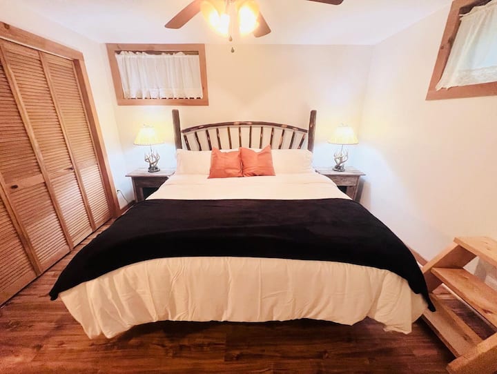 Spacious king room with rustic touches, cozy bedding, and a convenient pack and play in the closet for families traveling with young children.