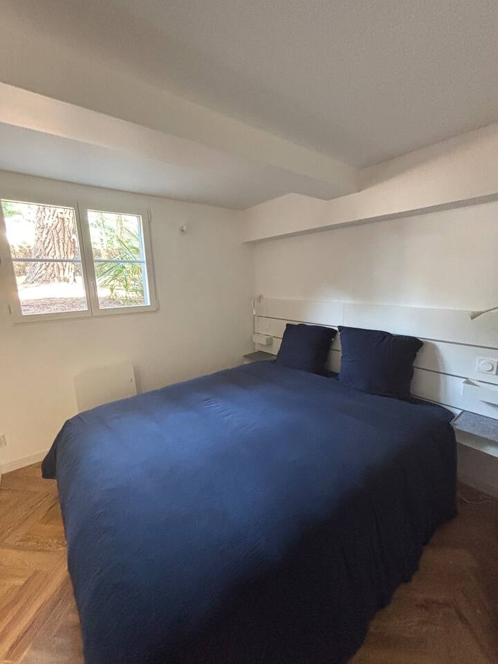 Chambre avec lit double 160 et salle d'eau dans le studio du rez-de-jardin