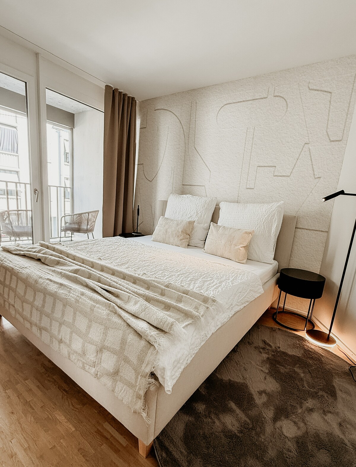 Slaapkamer met hoogwaardige boxspring, zacht beddengoed en stijlvol textiel – voor een goede nachtrust in een rustige sfeer. Toegang tot het balkon voor frisse lucht en een ontspannen start van de dag.