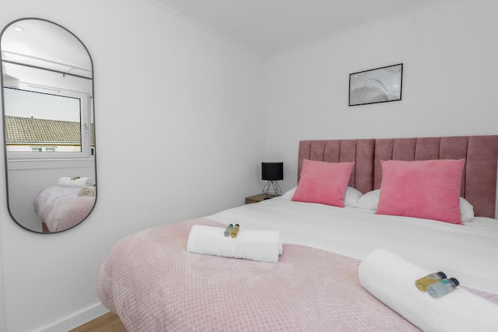 Sumérgete en la comodidad en esta elegante habitación con una lujosa cama tamaño king, suaves detalles rosados y toallas frescas para una estadía relajante.