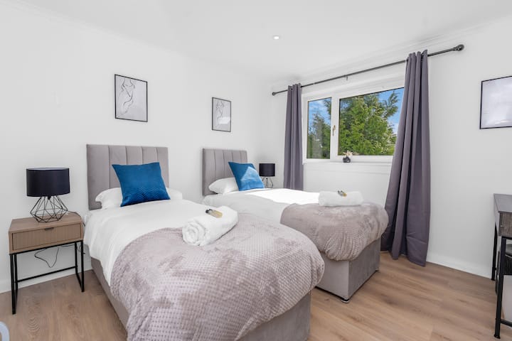 Habitación doble luminosa y espaciosa con lujosa ropa de cama, decoración moderna y vistas al jardín, perfecta para que amigos o familiares se relajen cómodamente.