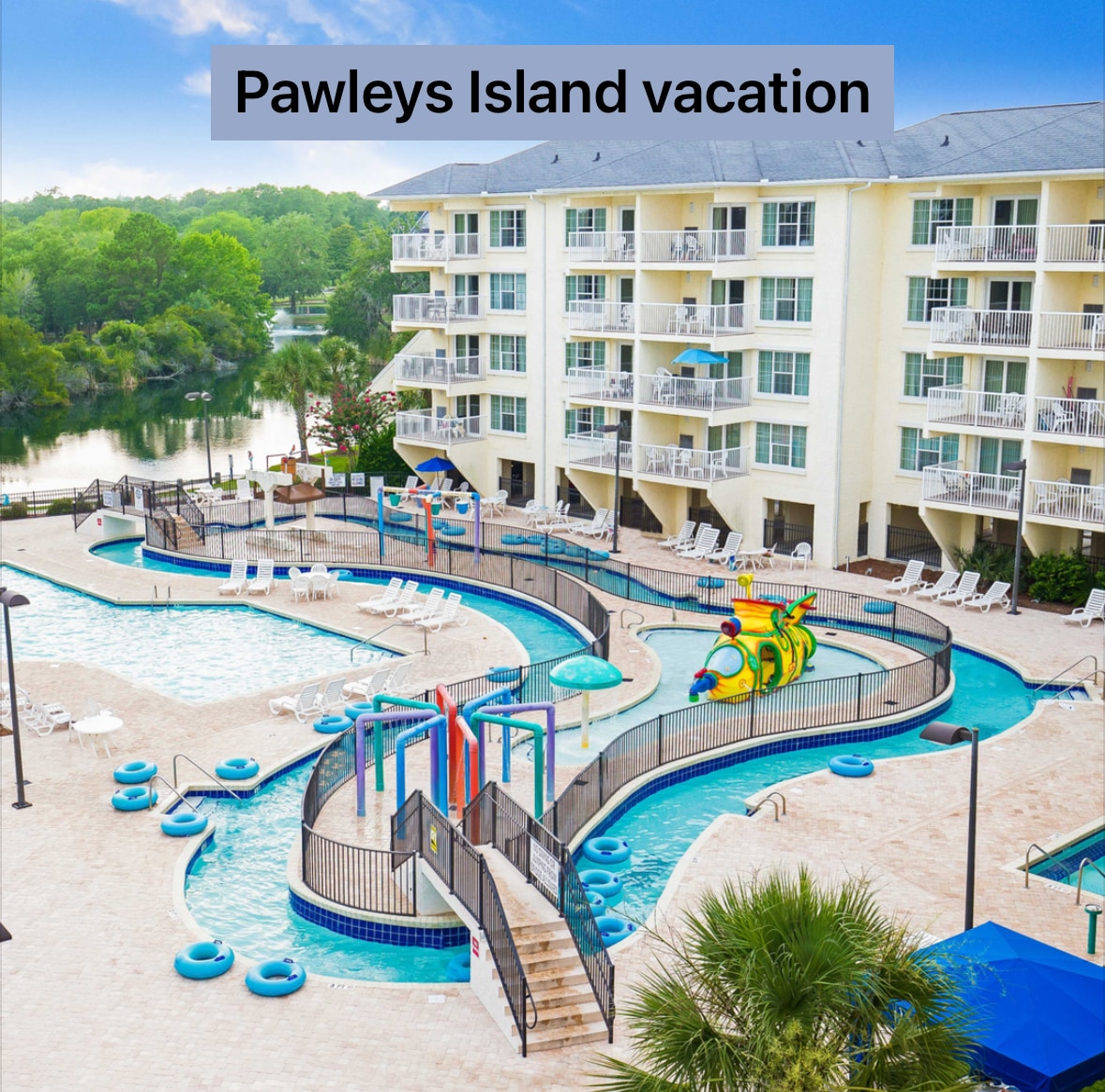 The image shows a vibrant outdoor pool area with a winding lazy river and colorful water features. Lounge chairs are arranged around the pool, and a backdrop of the condo complex and lush greenery is visible, enhancing the overall recreational appeal of the space.