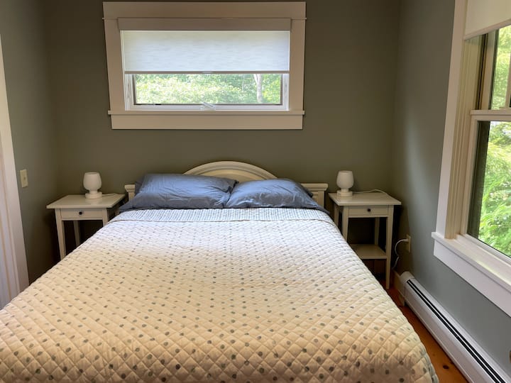 First-floor bedroom with queen bed and a view into the front garden