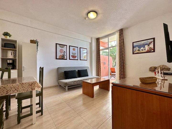 סלון מרווח עם ספה נפתחת, טלוויזיית מולטימדיה, שולחן.