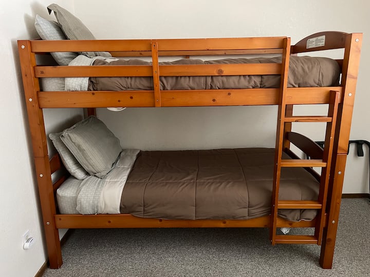Soveværelse på nederste etage med to køjesenge og en enkeltseng  
støder op til stuen/tekøkkenet. I skabet i dette soveværelse er der en Pack & Play-rejsevugge, højstole samt legetøj.