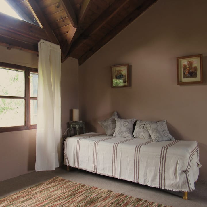 A plaza or sofa bed located in the open mezzanine that balconies the living room accessing by staircase shares the space with the work area that has a desk.