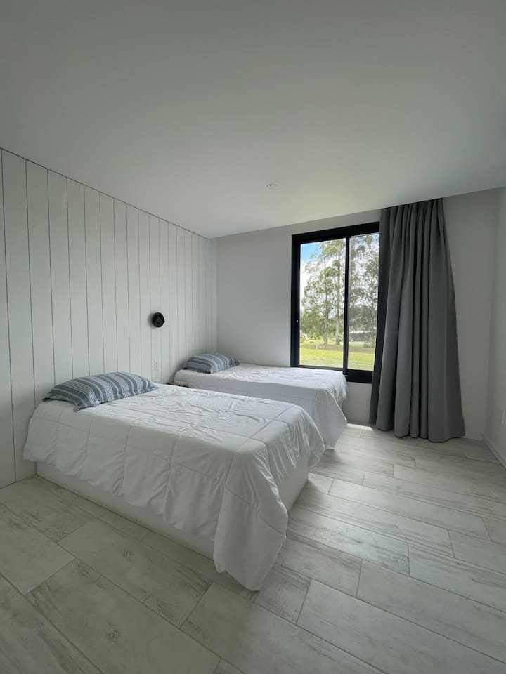 Chumba cha kulala chenye nafasi kubwa chenye vitanda 2 0.90x1.90. A/C na mapazia meusi.