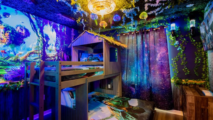 Zakoračite u čarobni svijet inspiriran Pandorom! Zidne slike s motivom bujne džungle, svjetla koja svijetle, posteljina s tematskim uzorcima i udoban krevet na kat stvaraju ambijent iz snova koji je savršen za obitelji i djecu koja traže avanturu, fantaziju, prirodu, uzbuđenje i nezaboravnu zabavnu spavaću sobu!