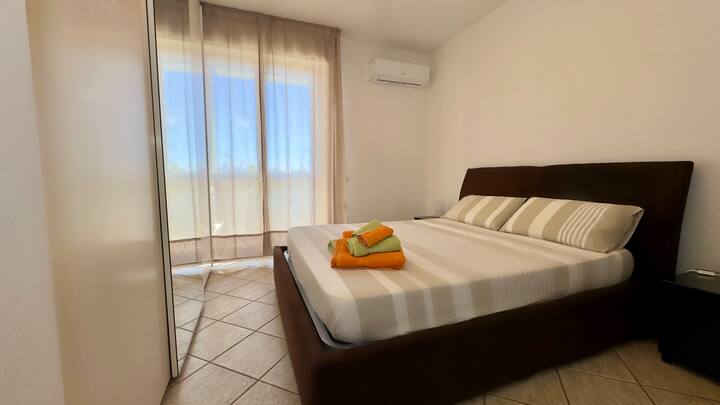 Chumba kikubwa cha kulala chenye nafasi kubwa, kilicho na kabati kubwa la nguo lenye viango, meza na kiyoyozi, kitakuruhusu kupumzika kwa starehe baada ya siku moja baharini au kugundua jiji.