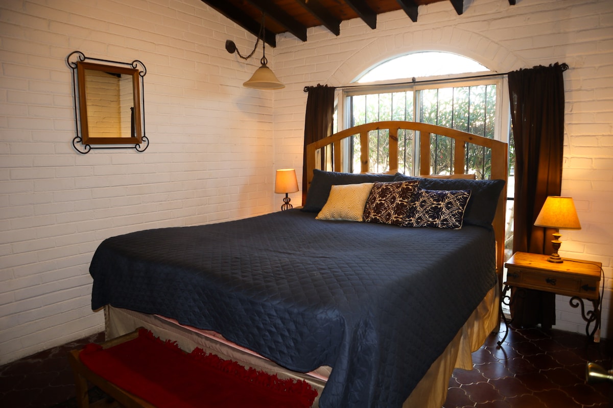 חדר שינה ראשי עם מיטה זוגית וחדר רחצה צמוד.