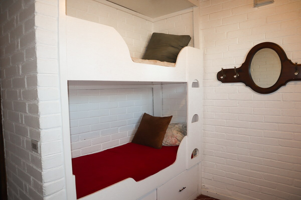 חדר שינה לילדים עם שלוש מיטות תינוק.