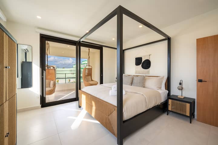 Chambre lumineuse avec lit king size et petit balcon pour profiter de la brise tropicale. 
Il dispose d'un placard et de la climatisation