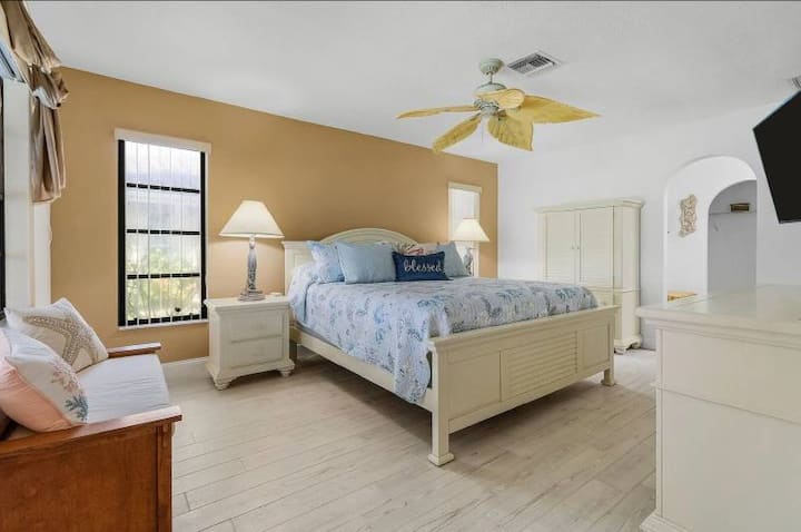 Chumba hiki cha kulala chenye nafasi kubwa kina kitanda cha ukubwa wa kifalme kilicho na mashuka safi na mapambo yaliyohamasishwa na kitropiki. Ukiwa na televisheni ya skrini bapa huongeza urahisi wa kisasa.