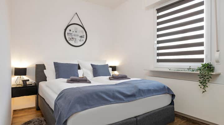 Спалня с едно двойно легло 160 x 200 см, спално бельо, няколко възглавници, опция за индукционно зареждане на мобилен телефон, закачалка за дрехи със закачалки