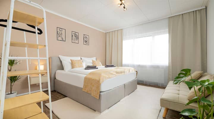 Спалня с едно голямо двойно легло 180 x 200 см, разтегателен диван 100 x 200 см, спално бельо, няколко възглавници, индукционно зареждане на мобилен телефон, закачалка за дрехи със закачалки