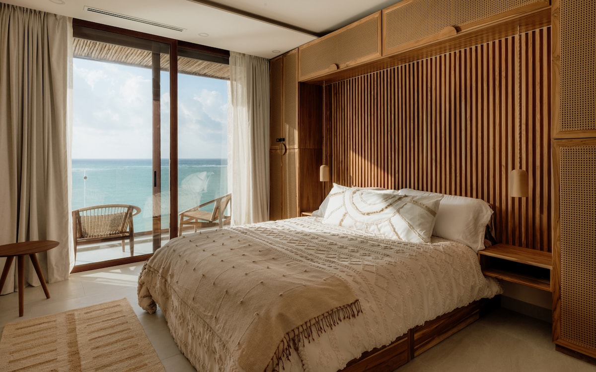 The master suite offers breathtaking ocean views from the king-sized bed, with direct balcony access and a luxurious en-suite bathroom.
