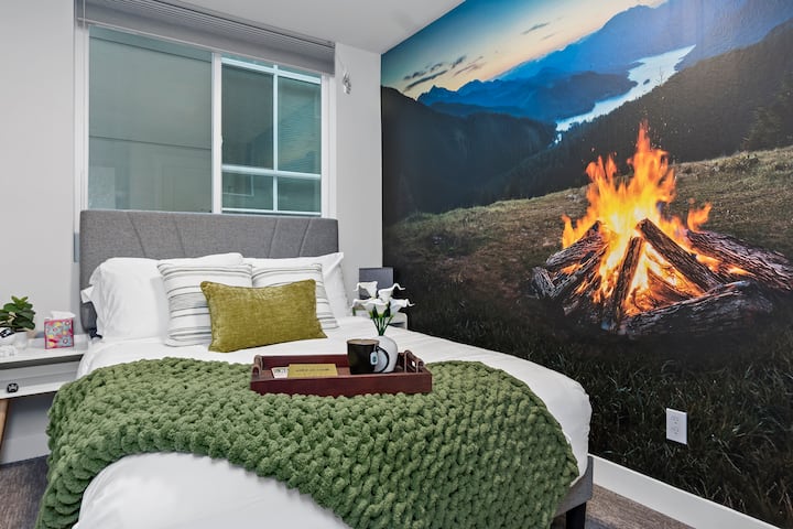 Sill ngrohtësinë e ambienteve të jashtme me këtë murale magjepsëse të zjarrit të kampit. Kjo dhomë gjumi e rehatshme ofron një atmosferë unike dhe relaksuese.