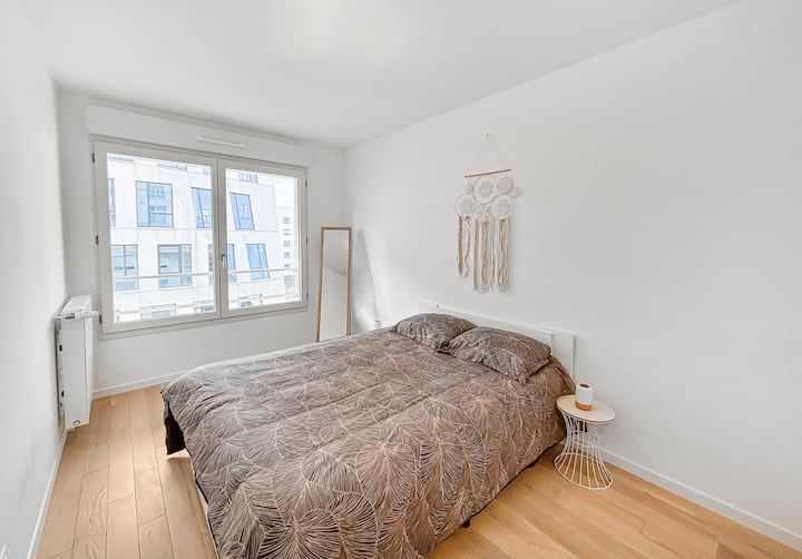 Una habitación elegante con una cama de matrimonio queen size y un gran vestidor. Decorada en un estilo minimalista, ofrece una vista relajante de la ciudad, ideal para un descanso óptimo después de un día ajetreado.