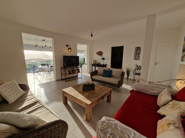 Sala de estar equipada con tres sofás y TV, da directamente a la gran terraza cubierta y también se beneficia de las vistas al mar.