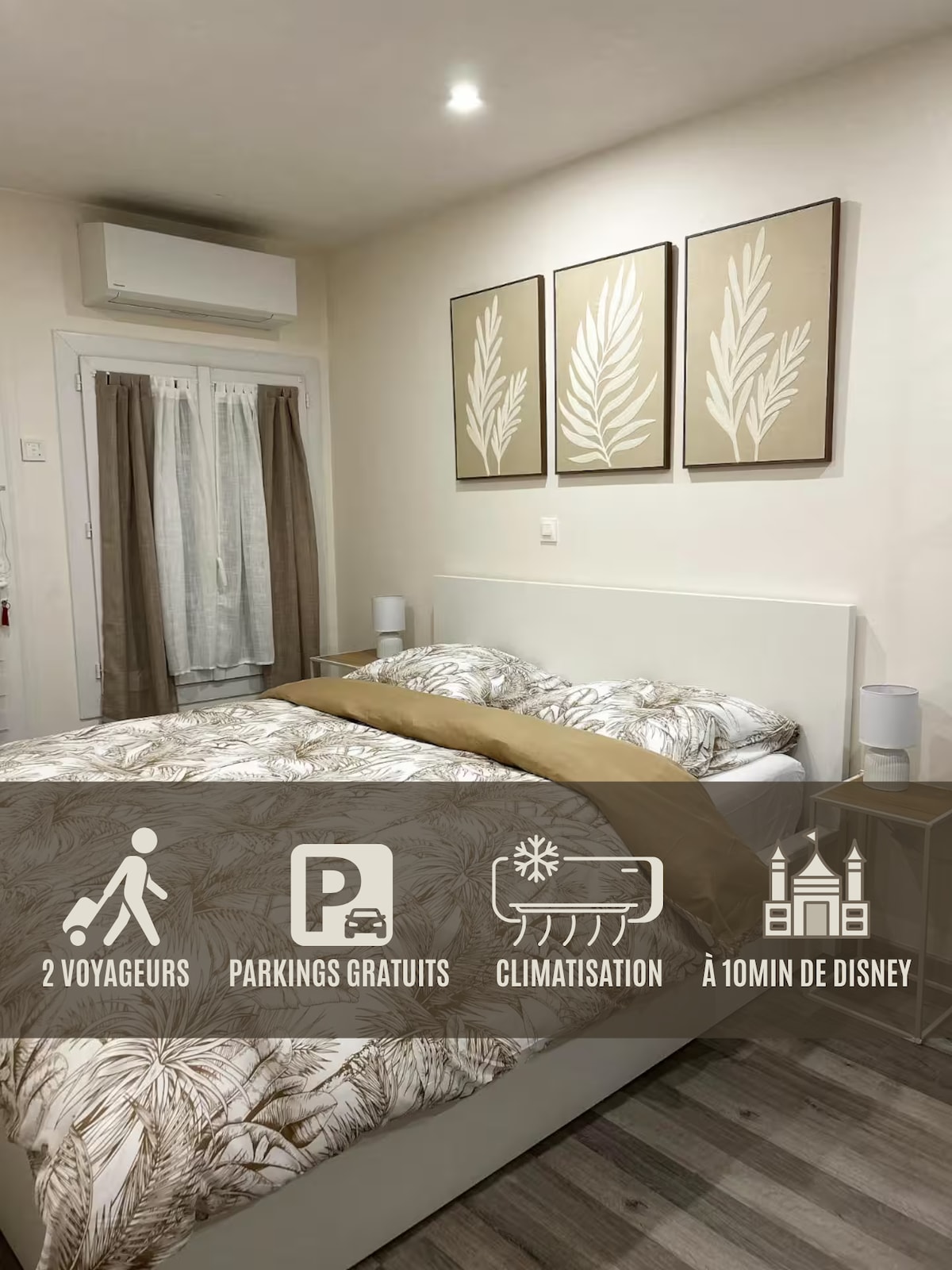 A cozy bedroom features a spacious bed adorned with a natural-patterned duvet. Decorative artwork of leaves is arranged above the bed. Two bedside tables and a window with curtains complete the serene atmosphere, while overhead air conditioning ensures comfort.