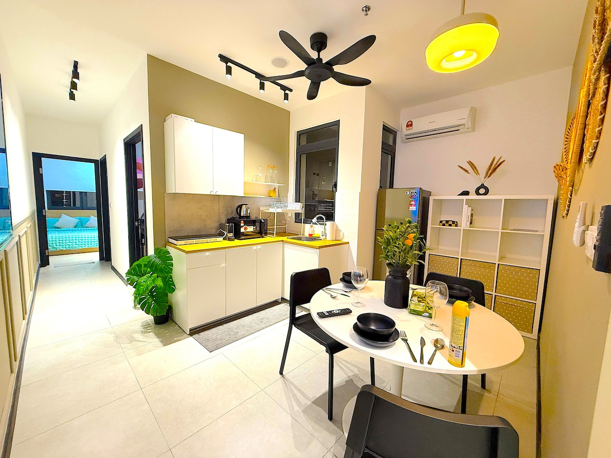 A modern kitchen and dining area are featured, showcasing sleek cabinetry and appliances. A round dining table is set with dishware and a center plant, while a ceiling fan circulates air above. Large windows provide views of the outdoor pool area.