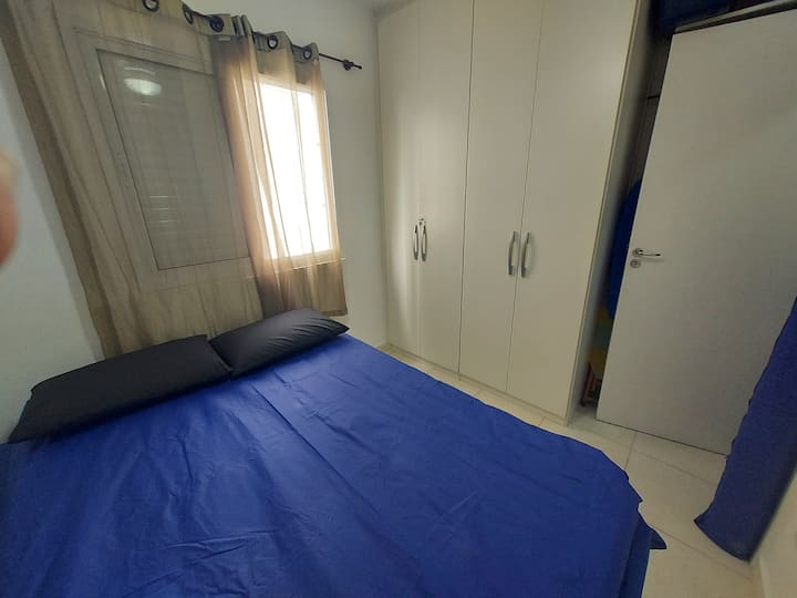 غرفة مجهزة بصندوق مزدوج ومكان لتخزين الملابس، مكيفة الهواء بمراوح سقف. 