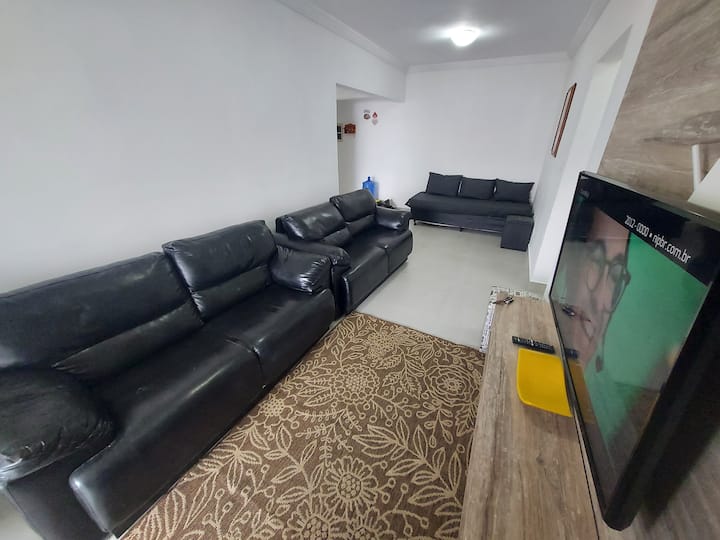 شاهد التلفزيون في سريرين مريحين على الأريكة. يحتوي المحيط أيضًا على مراوح سقف وباب وصول إلى الشرفة