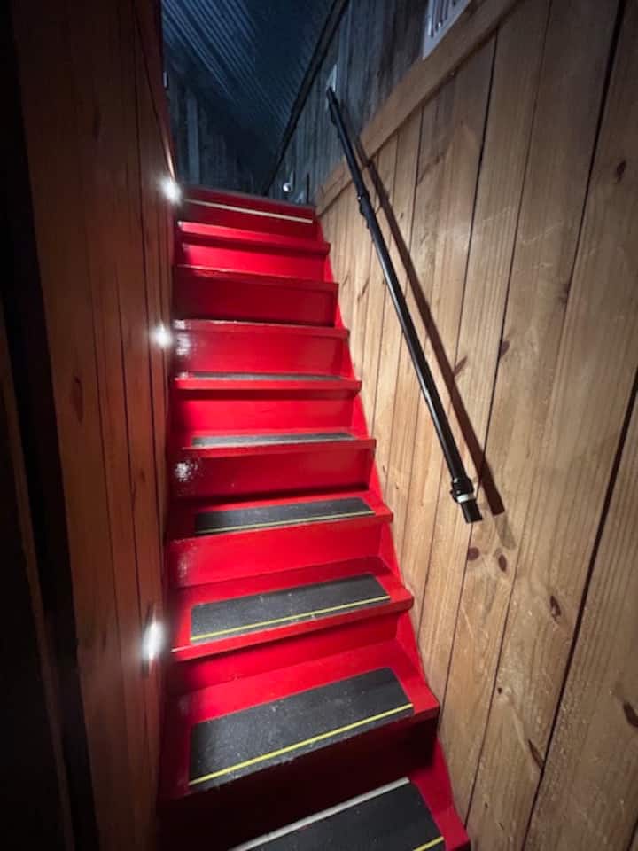 الدرج شديد الانحدار يرجى التمسك بالدرابزين؛ يرجى ملاحظة أن هذا شديد الانحدار ومضاء جيدًا؛ قد يضطر الأشخاص الطوال إلى الانتباه لرؤوسهم!