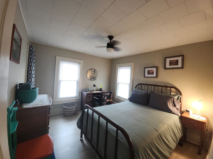 Dormitorio 3: cama completa con sillón, cómoda y escritorio con mesita de noche y luz y ventilador de techo.