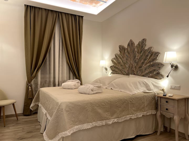 სტანდარტული საძინებელი საწოლი 14 კვმ.  (ლუქს-კლასის სააბაზანო) ხელნაკეთი ხელოსნური ავეჯით კლასიკური იტალიური ტრადიციის მიხედვით. ხელოსნური ხის თავსაფარი. დიდი ზომის მატრასები 180x200x40 სმ კომფორტისა და დასვენების უზრუნველსაყოფად