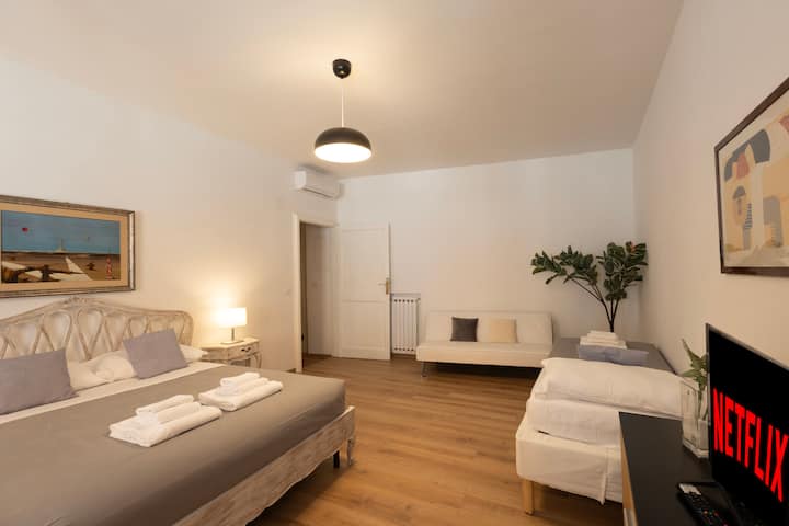 
غرفة معيشة مريحة ومشرقة بسرير مزدوج وسرير فردي وأريكة وتلفزيون. تغمر نافذتان كبيرتان الغرفة بالضوء الطبيعي، مما يخلقان جوًا مريحًا في قلب روما. مثالي للعائلات أو للمجموعات الصغيرة!