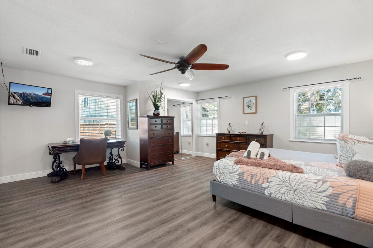 Голямо двойно легло със смарт телевизор и обособено работно пространство 