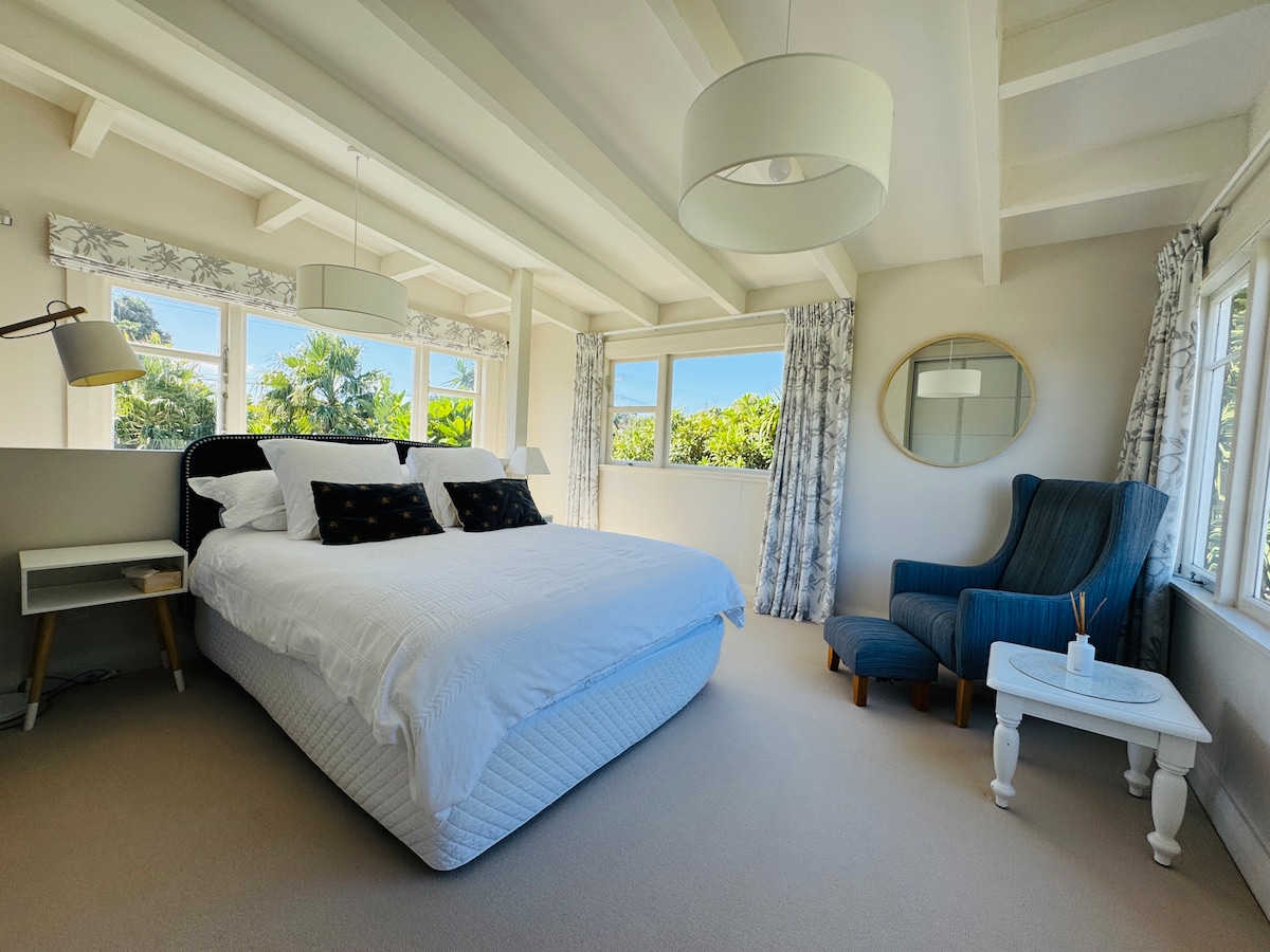 فقط أعلى الدرج غرفة النوم الرئيسية مع حمام داخلي في كوخ النخيل هي غرفة حالمة للاسترخاء فيها. تتمتع كل نافذة بإطلالات على الحديقة الاستوائية، والغرفة نفسها تتميز بطابع رائع مع أسقف عالية ومساحة كبيرة. 