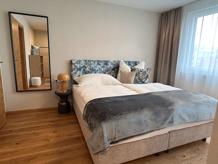 Спална соба со брачен кревет (широк 180 x 200 см), простор за складирање облека и директен пристап до бањата