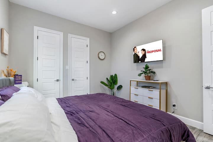 Kitanda cha ukubwa wa kifalme, kinachofaa kwa ajili ya kulala kwa utulivu. Mapambo ya kisasa ya chumba na rangi ya kutuliza huunda mazingira tulivu, yaliyoimarishwa na mwanga wa kutosha wa asili