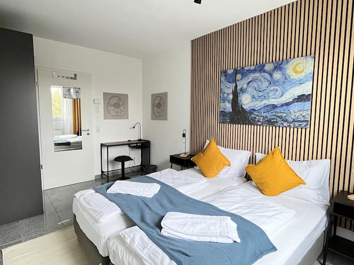 Chumba cha kulala cha watu 2 kilicho na kabati na viti pamoja na televisheni mahiri. Vitanda vinaweza kusukumwa kando au kusukumwa pamoja.